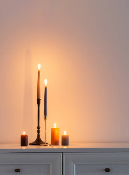 istock burning candles on white wooden shelf in white interior 1496870063