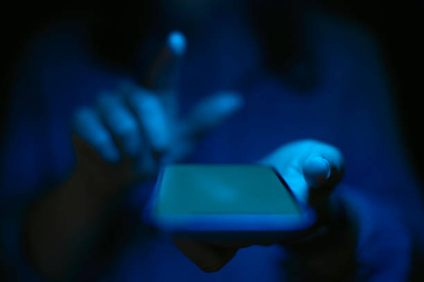 istock Close Up Of Woman Using Mobile Phone With Blue Lighting Effect 1496870318