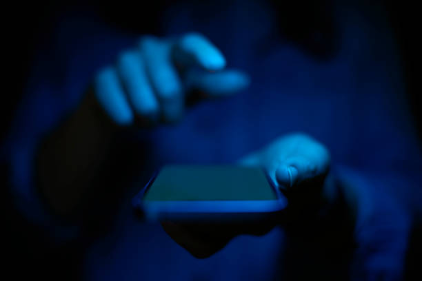 istock Close Up Of Woman Using Mobile Phone With Blue Lighting Effect 1496870343