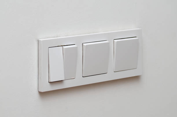 istock Block of three white plastic electrical switches on a white wall 1496872548