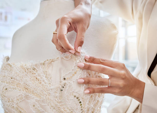 istock Hands, design and woman designer with needle for dress, pattern and details while fabric in her studio. Fashion designer, hand and creative businesswoman working on luxury, classic and elegant wear 1496875341