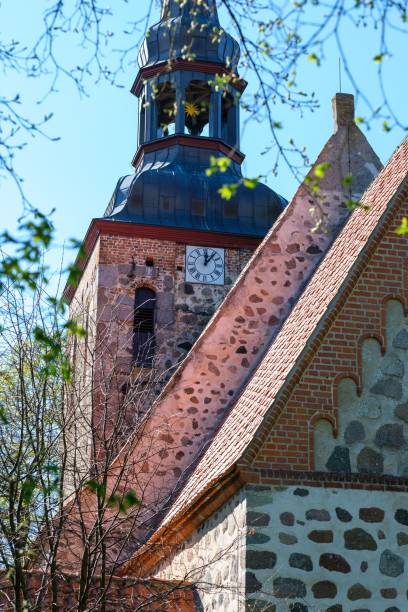 istock Historical church building featuring a tall tower with a clock face at the top in lush greenery 1496876018