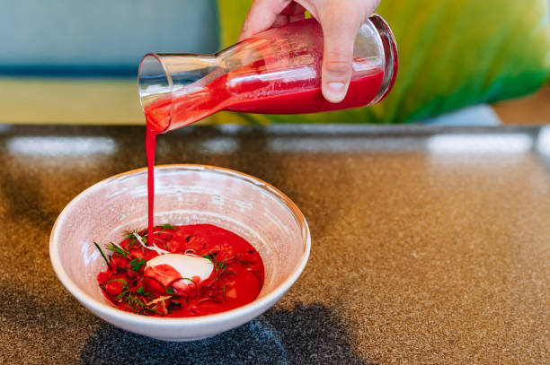 istock waiter pours cold beetroot soup into plate 1496876075