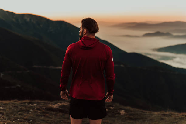 istock An athlete rests on top of a mountain after exhausting running training. 1496876300