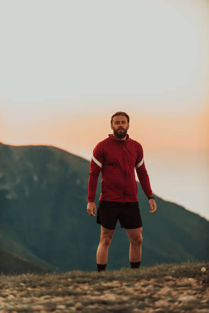 istock An athlete rests on top of a mountain after exhausting running training. 1496877291