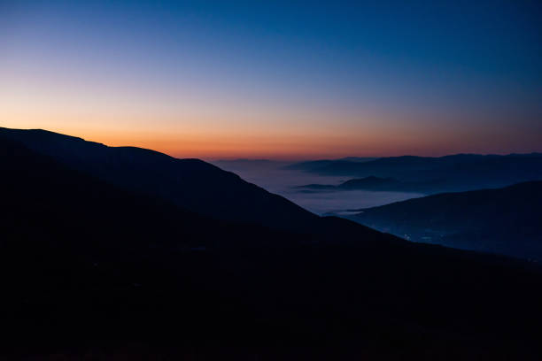 istock Mountain range with visible silhouettes through the morning colorful fog 1496877633