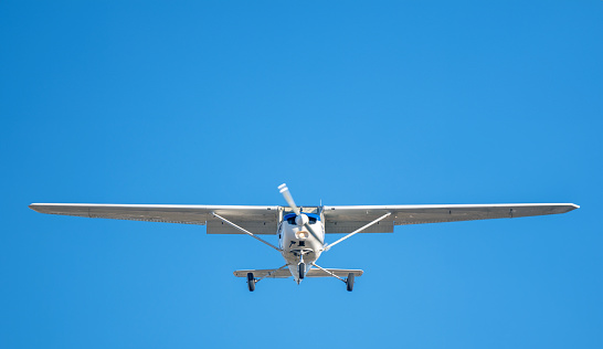 Private four passenger airplane flying on a clear, bright day. Cessna 172.