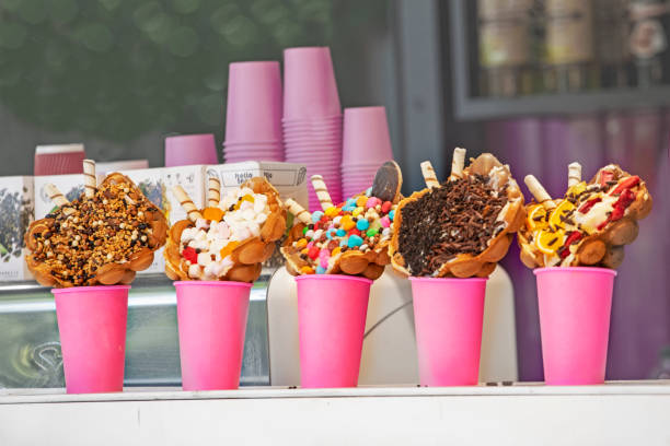 istock different varieties of ice cream in waffle cones with marmesh, nuts, sweets, coconut and chocolate chips in pink cups 1496879395