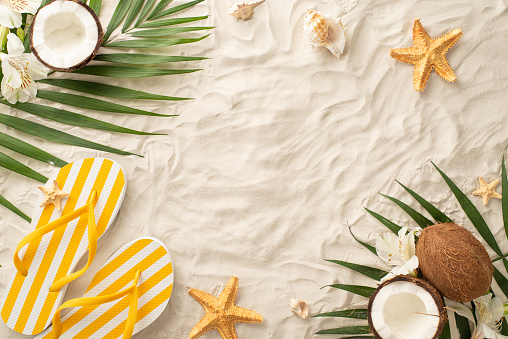 Embark on visual adventure into essence of summer with this captivating overhead arrangement: yellow flip-flops, shells, starfish, palm leaves, coconut, flowers on sandy shore, blank space for text
