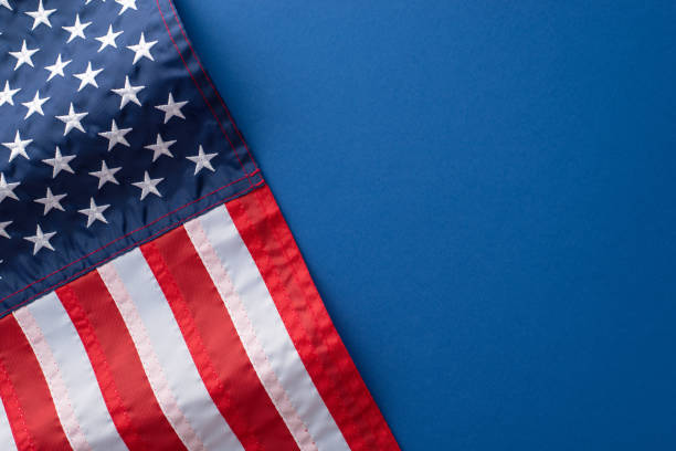 istock Symbolic item, like a wavy national flag, harmoniously placed on a blue background with an empty space, creating an inviting space for text or advertising during an Independence Day USA celebration 1496884402