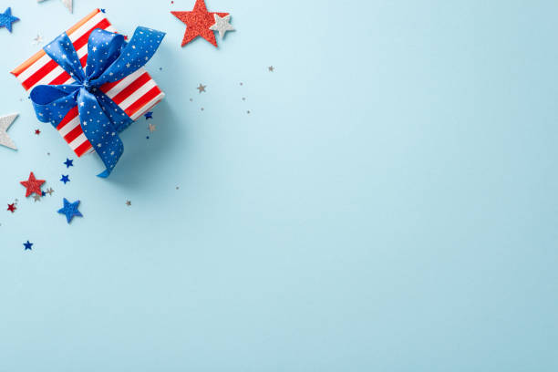 istock Party elements including confetti arranged in top view composition. Patriotic decor, shiny stars complete Independence Day USA theme. Giftbox add festive atmosphere on blue backdrop with space for ad 1496884774