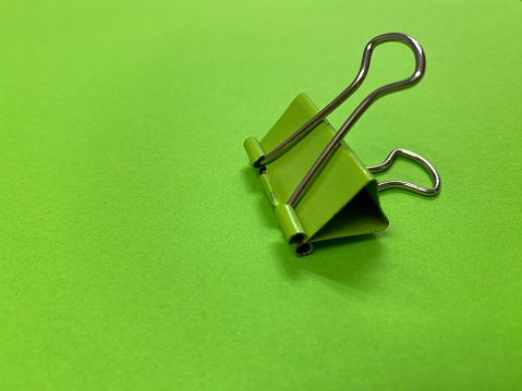 Green Paper clip isolated on green background