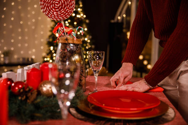 istock Young man setting up napkins on a dining table when preparing for a Christmas dinner 1496886325