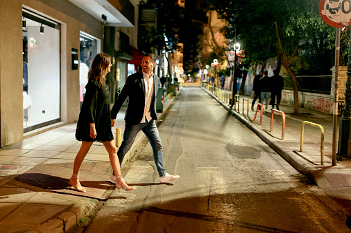 Man and woman walking around the city at night