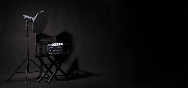 istock Black Director chair and clapper boardand studio light on black background. 1496886597