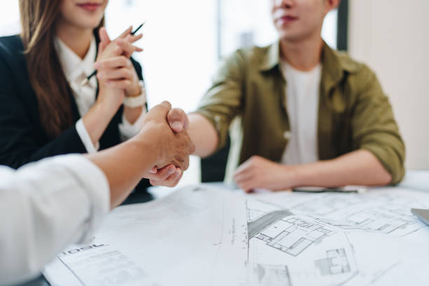 istock Engineers, designers and interior designers are handshake shack hands deal finalizing the design of interiors by discussing selecting materials and colors to design rooms to present to clients. 1496888611