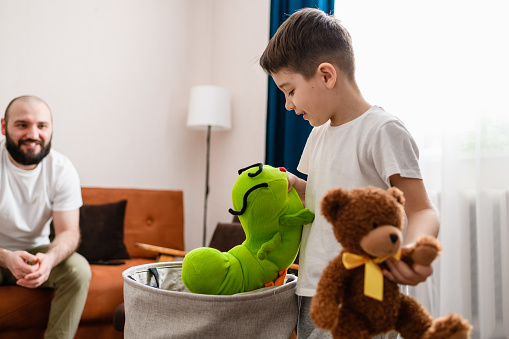 Preschooler male child boy play with soft toys at home apartment room interior with happy father, family time