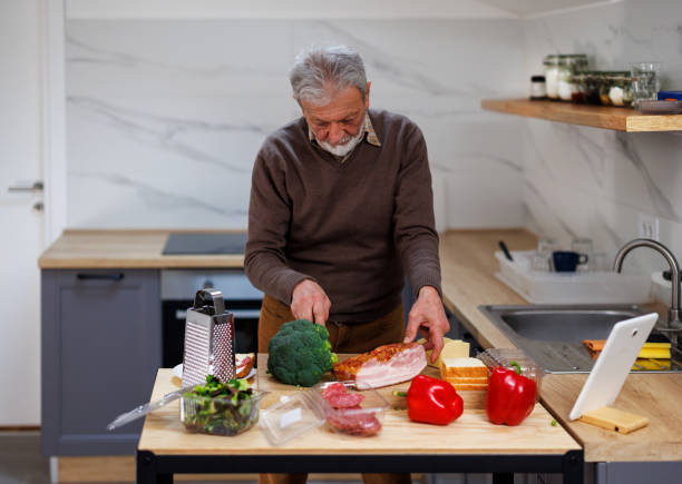 istock A male chef is preparing a meal with fresh vegetables and bacon. 1496891957