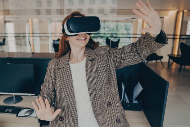 istock Woman trying to dodge something in virtual reality while working in office 1496892878