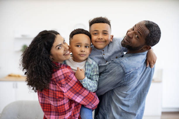 istock Man and woman with sons looking over shoulder in apartment 1496893630