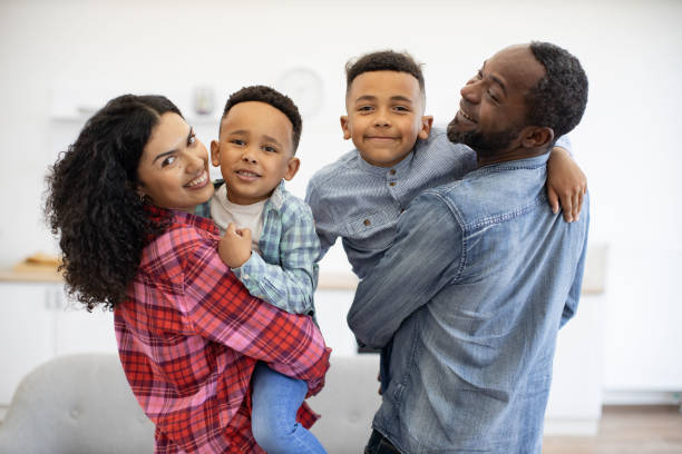 istock Man and woman with sons looking over shoulder in apartment 1496893632