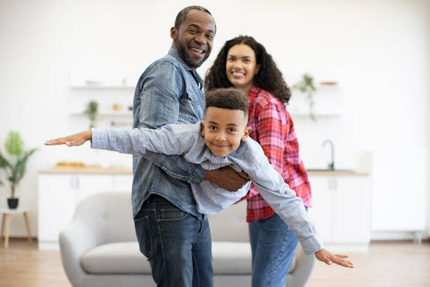 istock Son flying in parents' arms at home during weekend 1496893643