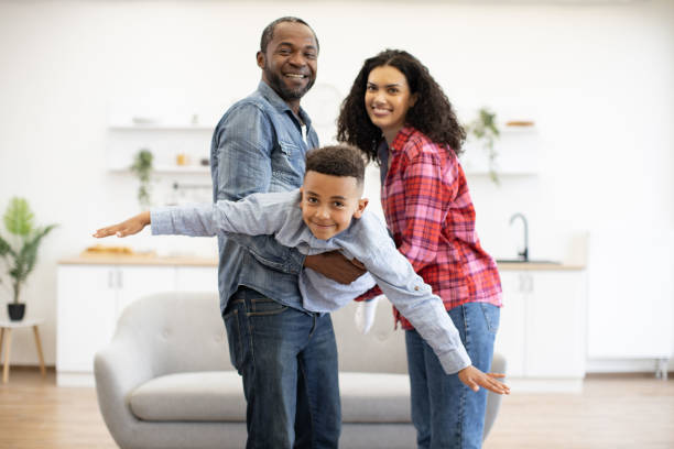 istock Son flying in parents' arms at home during weekend 1496893659