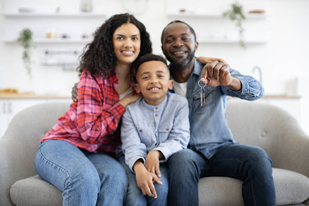 istock Father showing keys of new flat while hugging wife and son 1496893668