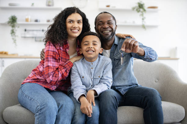 istock Smiling spouses and kid sitting on sofa in lately got flat 1496893670