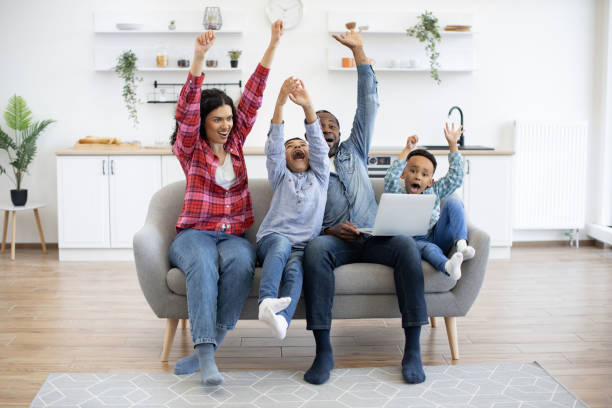 istock People raising hands while watching match on laptop at home 1496893673