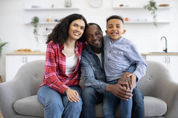 istock Little boy hugging parents while posing on sofa at home 1496893684