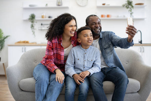 istock Spouses with son having online phone call in lounge at home 1496893700