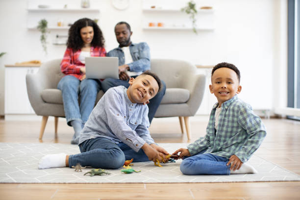 istock Boys posing with toy animals while couple typing on laptop 1496893742