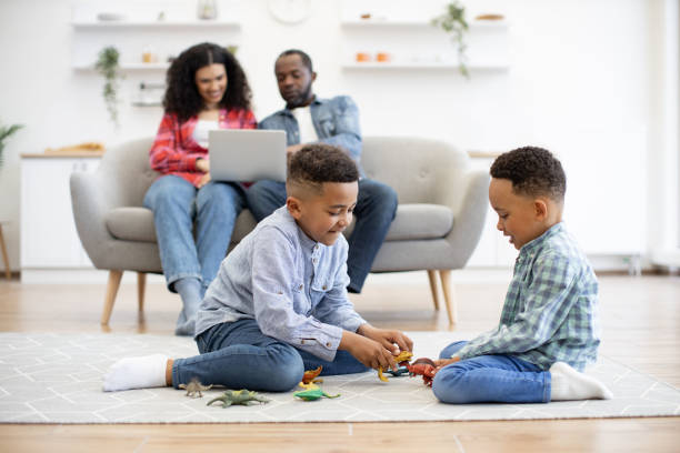 istock Kids playing with toys while parents using laptop in kitchen 1496893744