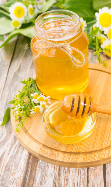 istock Jar of fresh honey on wooden board 1496897603