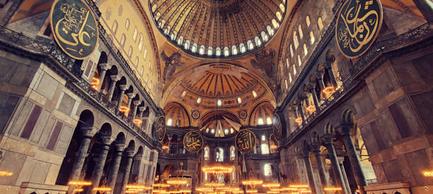 istock Empty interior of Istanbul's Santa Sophia Cathedral without people with a panorama inside adorned with intricate chandeliers, ornate decorations, domes, and windows, embodying the architecture 1496897733