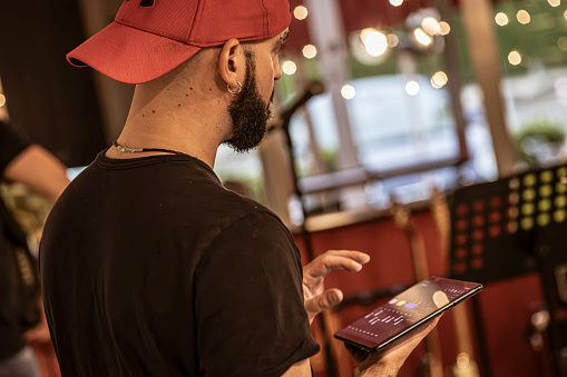 A skilled sound engineer uses a tablet to fine-tune the audio levels during a dynamic live concert performance.
