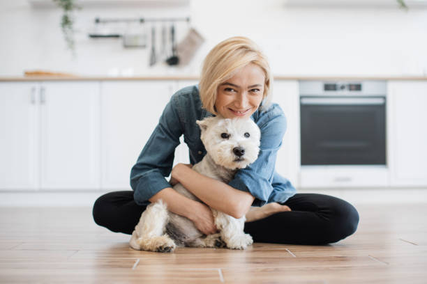 istock Woman hugging little dog while posing on floor in kitchen 1496898114