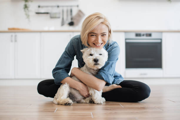 istock Woman hugging little dog while posing on floor in kitchen 1496898143