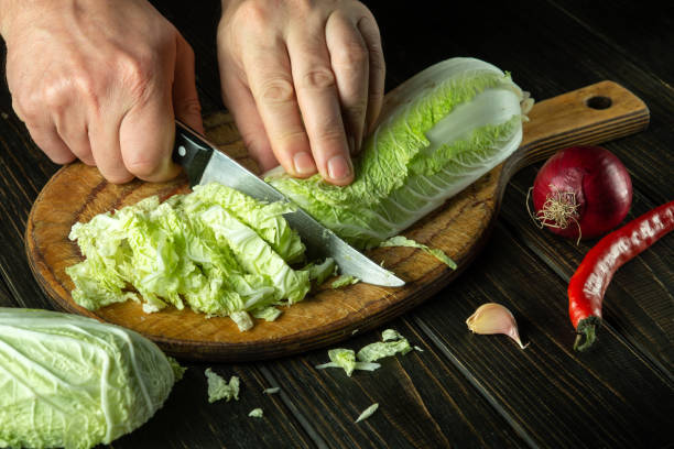 istock The cook cuts fresh cabbage with a knife. Cooking vegetable salad in the restaurant kitchen. The idea of a vegetable diet. 1496898285