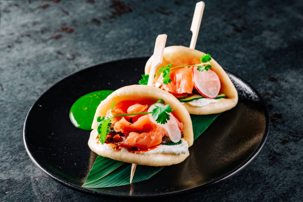 Burger asiatique, gua bao, à base de brioche chinoise, saumon et légumes dans l’assiette - Photo