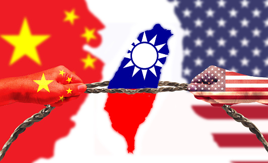 United States and China flags combined fist together. Taiwan flag in tug of war. Describe the concept of U.S.-China competition and the importance of Taiwan semiconductors