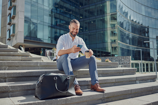 Stairs, city and man with a smartphone, typing and connection with entrepreneur, social media and network. Male person, employee on steps and happy consultant with a cellphone, mobile app and contact