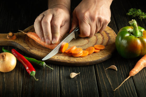 istock The chef cuts carrot on a cutting board for preparing a vegetarian lunch or breakfast. Delicious healthy food 1496901588