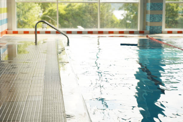 istock Against the background of the panoramic window is a swimming pool prepared for training without people. Clear blue water with dividing lines for swimming. With space to copy. High quality photo 1496901690
