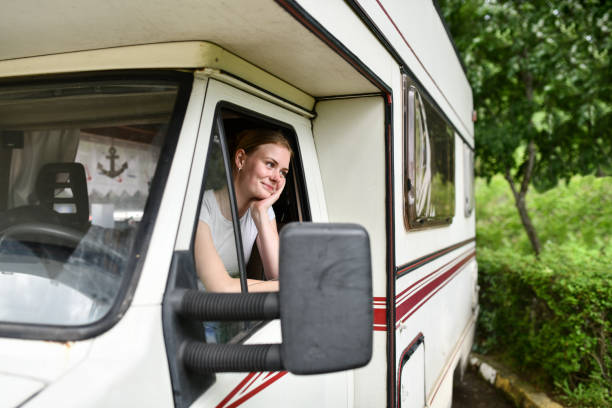 istock Beautiful Blond Female Day Dreaming While Relaxing In RV Cockpit In Nature 1496905977