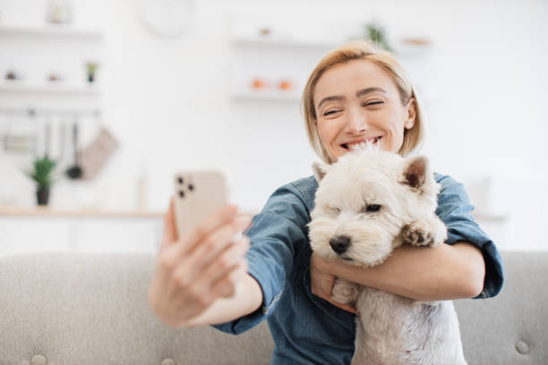 istock Woman with phone cuddling dog while getting self-portrait 1496906390