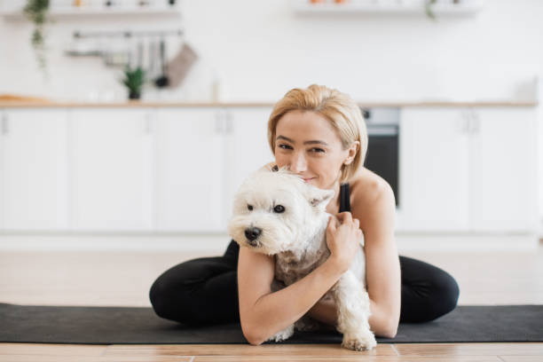 istock Female hugging small dog during yoga workout at home 1496906414