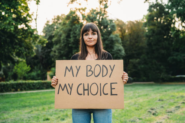 A woman is holding a cardboard with the text "My body my choice" stock photo