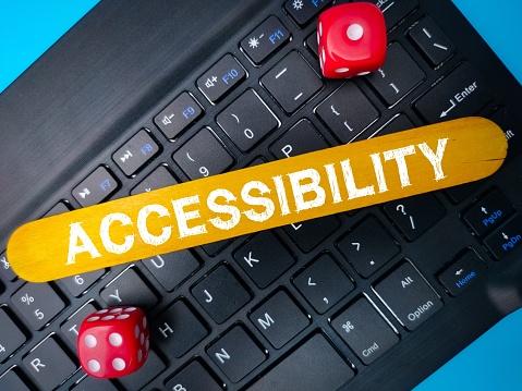 A close-up image of a yellow sign with 'Accessibility' text on a computer keyboard